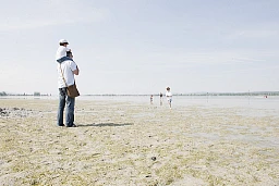 Un père marche avec ses fils samedi (23/04/11) sur le lit presque asséché du lac de Constance, près de Triboltingen (TG). Les températures estivales et le manque d&#39;eau dû à la sécheresse prolongée
