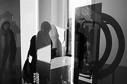 Teilnehmer einer Führung spiegeln sich im und scheinen durch das Werk von Charles Mason im Cent