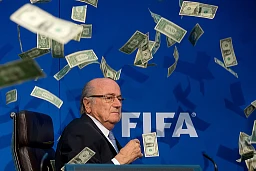 Komiker Simon Brodkin (nicht im Bild) wirft FIFA-Präsident Joseph S. Blatter während einer Pressekonferenz anlässlich der außerordentlichen Sitzung des FIFA-Exekutivkomitees am 20. Juli 2015 im FIFA-Hauptquartier in Zürich, Schweiz, mit Dollarscheinen zu. (Foto: Philipp Schmidli/Getty Images)