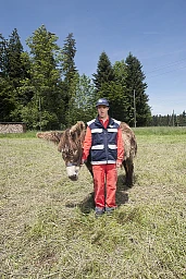 Schwarzenegg, May 28, 2015. This portrait shows Vladimir Slokar, a resident of the Höchmatt residential home in Schwarzenegg. He is standing with one of the home&#39;s donkeys in a field adjacent to the home. The donkeys are cared for, fed, and walked daily by the residents.