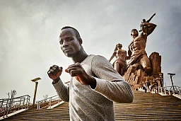 Kherou Ngor, un giovane e affermato lottatore di pesi leggeri del distretto di Ngor a Dakar, posa davanti al "monumento del Rinascimento africano" il 3 marzo 2015. Si allena lì tre volte a settimana sulle lunghe scale. Kherou Ngor sogna di diventare un giorno il "Re delle arene".