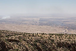 Auf dem Gipfel des Sindschar-Berges sieht man rechts im Bild die Überreste der Stadt Sindschar. Die gerade Straße in der Mitte verläuft nahe der Frontlinie, und der IS besetzt weiterhin die Dörfer links im Bild.