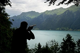 Ein Schütze zielt auf eine Tontaube, kurz vor dem Abdrücken, Sicht auf den Brienzersee. Ein Schütze zielt auf eine Tontaube, kurz vor dem Abdrücken, Sicht auf den Brienzersee.