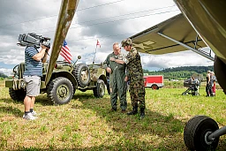Der OK-Präsident (rechts) richtet die Uniform des Piloten, während ein Videojournalist darauf wartet, ein Interview führen zu können.