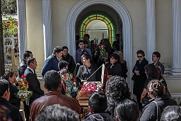 Dans le cimetière de Cochabamba, les proches d'un défunt se retrouvent avant l'entrée du cercueil dans la crypte familiale.