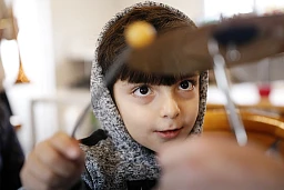 Migrantenkinder, die in Plastikhütten auf dem Campingplatz Bois de Bay in Genf leben, nehmen Musikunterricht mit dem Ziel, eine Blaskapelle zu gründen.