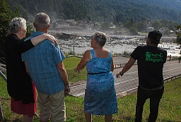 Switzerland. Canton Graubunden. Bregaglia valley. Bondo. People look at a second massive landslide while the remote village is still recovering from a huge landslide caused by a giant rockslide swept down from Piz Cengalo on August 23, 2017. The four people who had returned to their homes had to be evacuated from the village for the second time. The mudslide smash the carpentry factory and equipment that was being used to clear debris from the previous landslide. 25.08.2017 © 2017 Didier Ruef
