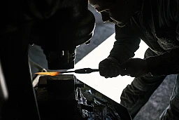 Messerschmied Thomas Lampert erhitzt den Stahl bis er hellrot leuchtet und schmiedet ihn anschliessend mit dem Maschinenhammer.