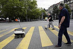 A Swiss Post self-driving delivery robot, capable of carrying up to 10 kg over 1 kilometer, with a speed up to 6 km/h, delivers a package from the department store Jelmoli during a press presentation for the start of the service in Zurich, Switzerland, September 8, 2017. REUTERS/Moritz Hager