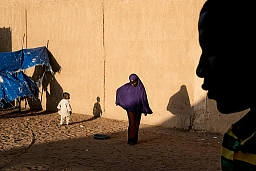 Une femme et son enfant accompagnant des anciens membres de la secte Boko Haram au Nigéria, se rendent dans le quartier réservé aux femmes dans le centre des repentis de Boko Haram à Goudou Maria (Niger).
