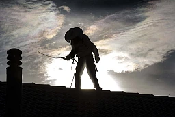 Gabriel Favre,responsable technique de l'entreprise Eradic, s'occupe de l'éradication des nids de guêpes - il travaille ici sur une toiture, les guêpes se sont introduites sous les tuiles.