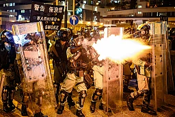 Die Einsatzpolizisten feuern Tränengas Geschosse auf vorrückende Demonstranten Die Einsatzpolizisten feuern Tränengas Geschosse auf vorrückende Demonstranten