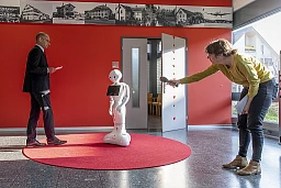 Sowohl der Stadtpräsident von Kloten, Rene Huber, und eine Journalistin zeigen Distanz zum Roboter. Sowohl der Stadtpräsident von Kloten, Rene Huber, und eine Journalistin zeigen Distanz zum Roboter.