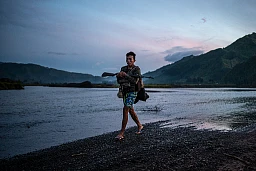 Ein Stammeskrieger eines mit der Philippinischen Armee Volksstammes überquert einen Fluss während einer Armeeoperation gegen die NPA im Zentrum von Mindanao.