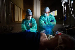 Kurz vor Mitternacht: Erschöpfte Pflegerin und Pfleger am Bett eines intubierten Patienten