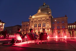 Schaulustige auf Campingstühlen erfreuen sich über das rot beleuchtete Bundeshaus, am 22. Juni 2020 in Bern. Die Organisation "Night of Light" macht mit der Aktion auf die prekäre Situation des durch die Pandemie gebeutelten Event-Business aufmerksam. (KEYSTONE/Alessandro della Valle) Schaulustige auf Campingstühlen erfreuen sich über das rot beleuchtete Bundeshaus, am 22. Juni 2020 in Bern. Die Organisation "Night of Light" macht mit der Aktion auf die prekäre Situation des durch die Pandemie gebeutelten Event-Business aufmerksam. (KEYSTONE/Alessandro della Valle)