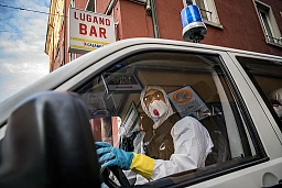 Ein Polizist in Schutzkleidung verlässt die Zürcher Langstrasse, nachdem er den Prostituierten eine Quarantäneverfügung übergeben hat.