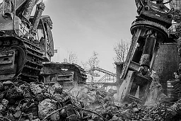 Der 750 t schwere Abbruchbagger reisst Eisenbeton aus einer Wand.