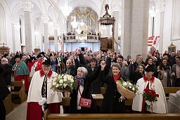 La nouvelle conseillere federale Elisabeth Baume-Schneider, au centre a gauche, chante la Rauracienne et tient la main de la conseillere federale sortante Simonetta Sommaruga, au centre a droite, devant son mari Pierre-Andre, son fils Luc, et Noemie Aubry, a l'occasion d'une reception en son honneur, ce jeudi 15 decembre 2022, dans l'église de Les Breuleux. (KEYSTONE/Anthony Anex) La nouvelle conseillere federale Elisabeth Baume-Schneider, au centre a gauche, chante la Rauracienne et tient la main de la conseillere federale sortante Simonetta Sommaruga, au centre a droite, devant son mari Pierre-Andre, son fils Luc, et Noemie Aubry, a l'occasion d'une reception en son honneur, ce jeudi 15 decembre 2022, dans l'église de Les Breuleux. (KEYSTONE/Anthony Anex)