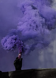 Eine Person hält eine Rauchpetarde in die Luft. Eine Person hält eine Rauchpetarde in die Luft.