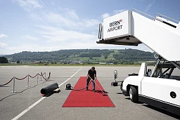 An employee of the Swiss confederation vacuums the red carpet ahead of the arrival of Zuzana Caputova, President of the Slovak Republic to a two day state visit, at the Bern-Belp Airport in Belp, Switzerland, Thursday, May 19, 2022. (KEYSTONE/Anthony Anex)