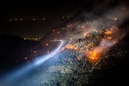 A helicopter carries water to a wildfire on the flank of a mountain in Bitsch near Brig A helicopter carries water to a wildfire on the flank of a mountain in Bitsch near Brig
