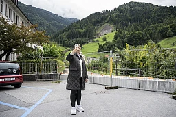 Eine Frau filmt sich vor den Geroell- und Schlammassen in Schwanden, aufgenommen am Mittwoch, 30. August 2023. Wie die Kantonspolizei am Vorabend mitteilt, zieht sich der Erdrutsch auf eine Laenge von rund 400 Metern hin. Ein halbes Dutzend Haeuser seien verschuettet oder zerstoert worden. (KEYSTONE/Ennio Leanza)