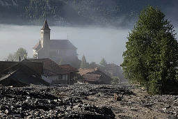 Eine Geroelllawine hat Teile des Dorfs oberhalb der Kirche verschuettet, am Dienstag, 13. August 2024 in Brienz. Am Vorabend haben heftige Gewitter einen Murgang ausgeloest und Gebaeude, parkierte Fahrzeuge, Strassen sowie Infrastruktur des oeffentlichen Verkehrs beschaedigt. (KEYSTONE/Alessandro della Valle)