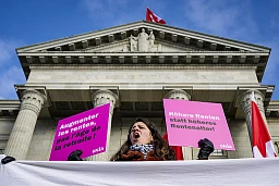 Une femme manifeste devant la presse pendant une audience au Tribunal fédéral sur les recours contre la votation sur le relèvement de l'âge de la retraite des femmes le jeudi 12 decembre 2024 a Lausanne. Une femme manifeste devant la presse pendant une audience au Tribunal fédéral sur les recours contre la votation sur le relèvement de l'âge de la retraite des femmes le jeudi 12 decembre 2024 a Lausanne.